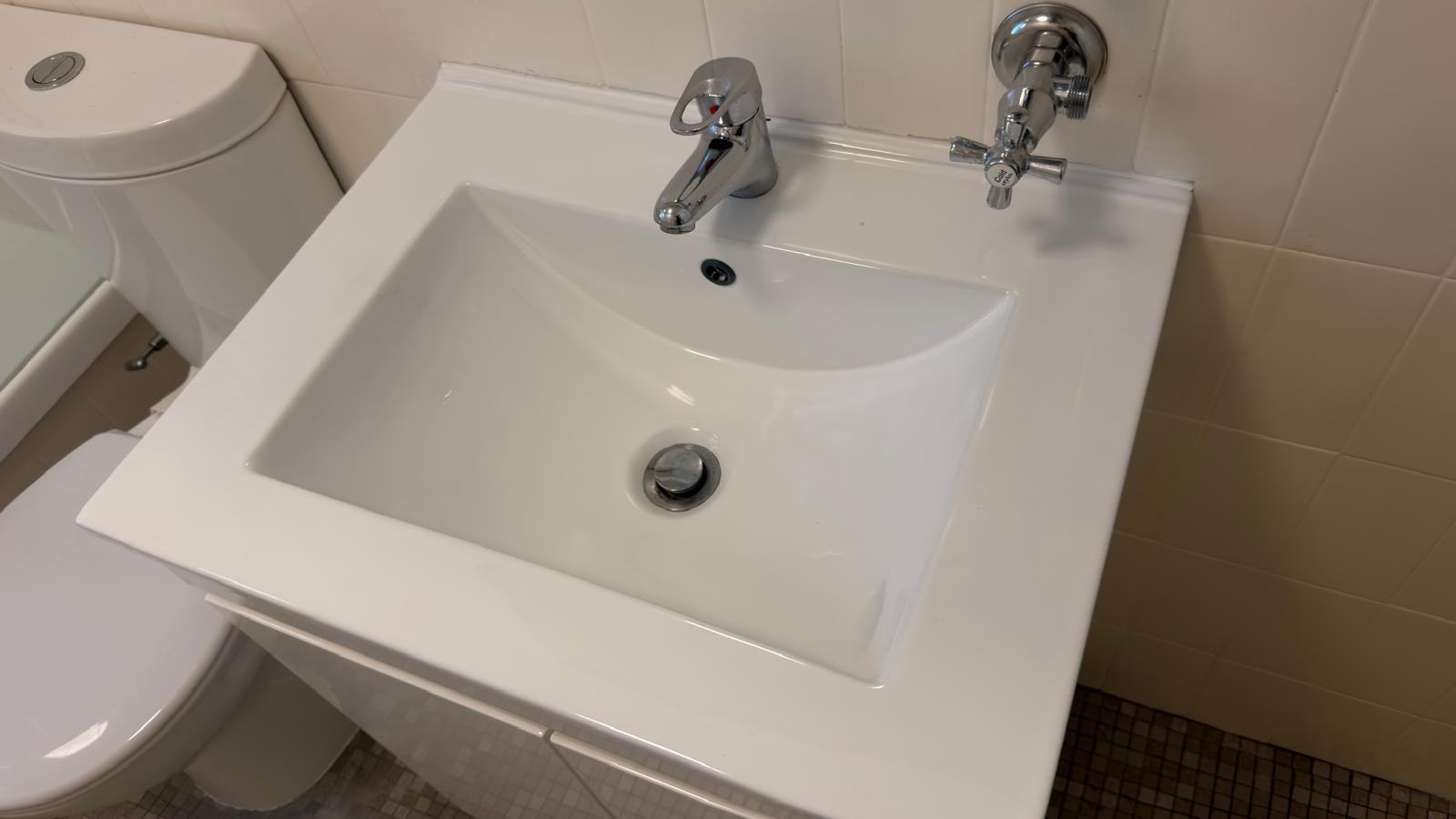 White bathroom basin with chrome taps after cleaning